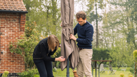 Dos personas instalando su parasol en su jardín