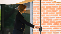 Una mujer ajustando su parasol